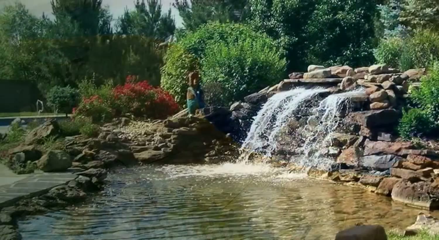 Stone waterfall into a backyard pond — TenderCare project