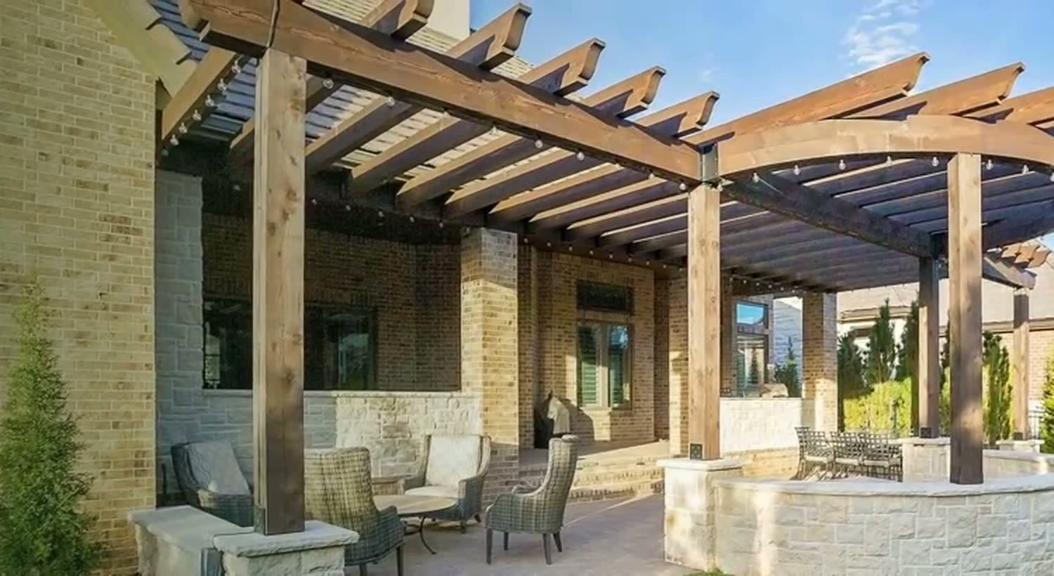 Curved cedar pergola over a stone patio — TenderCare project